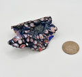 Vintage Kenworth Fordite piece showing layered red, white, blue and dark automotive paint patterns